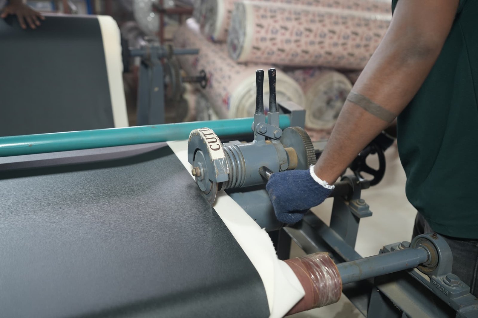 Technician trimming and rolling laminated fabric on the cutting line